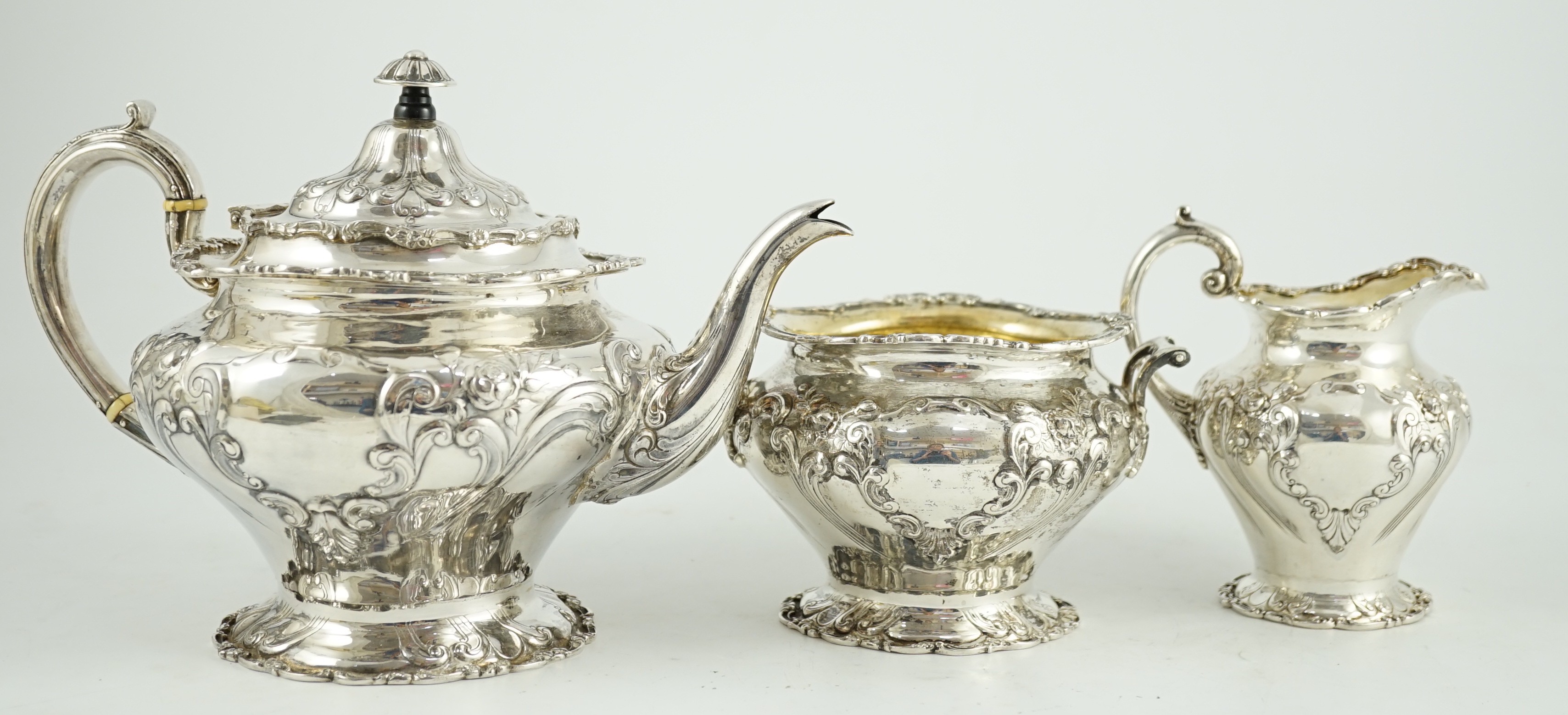 An Edwardian Scottish repousse silver three piece tea set, by Robert Scott